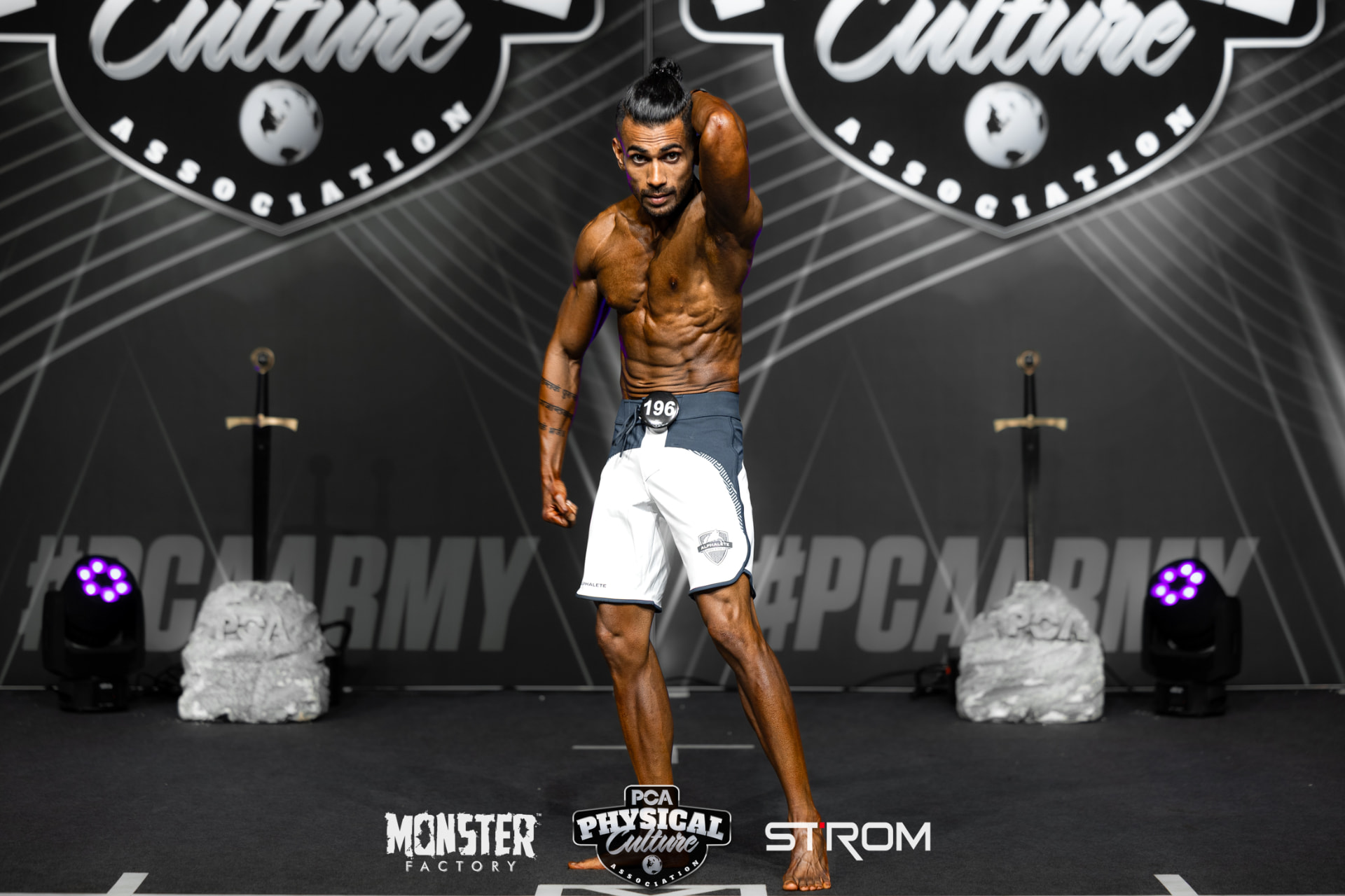 Abhishek posing on stage during a physique competition